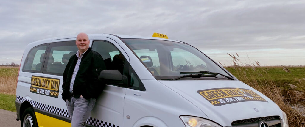 Professionele taxichauffeur staat naast zijn witte taxi met gele taxi kenmerken